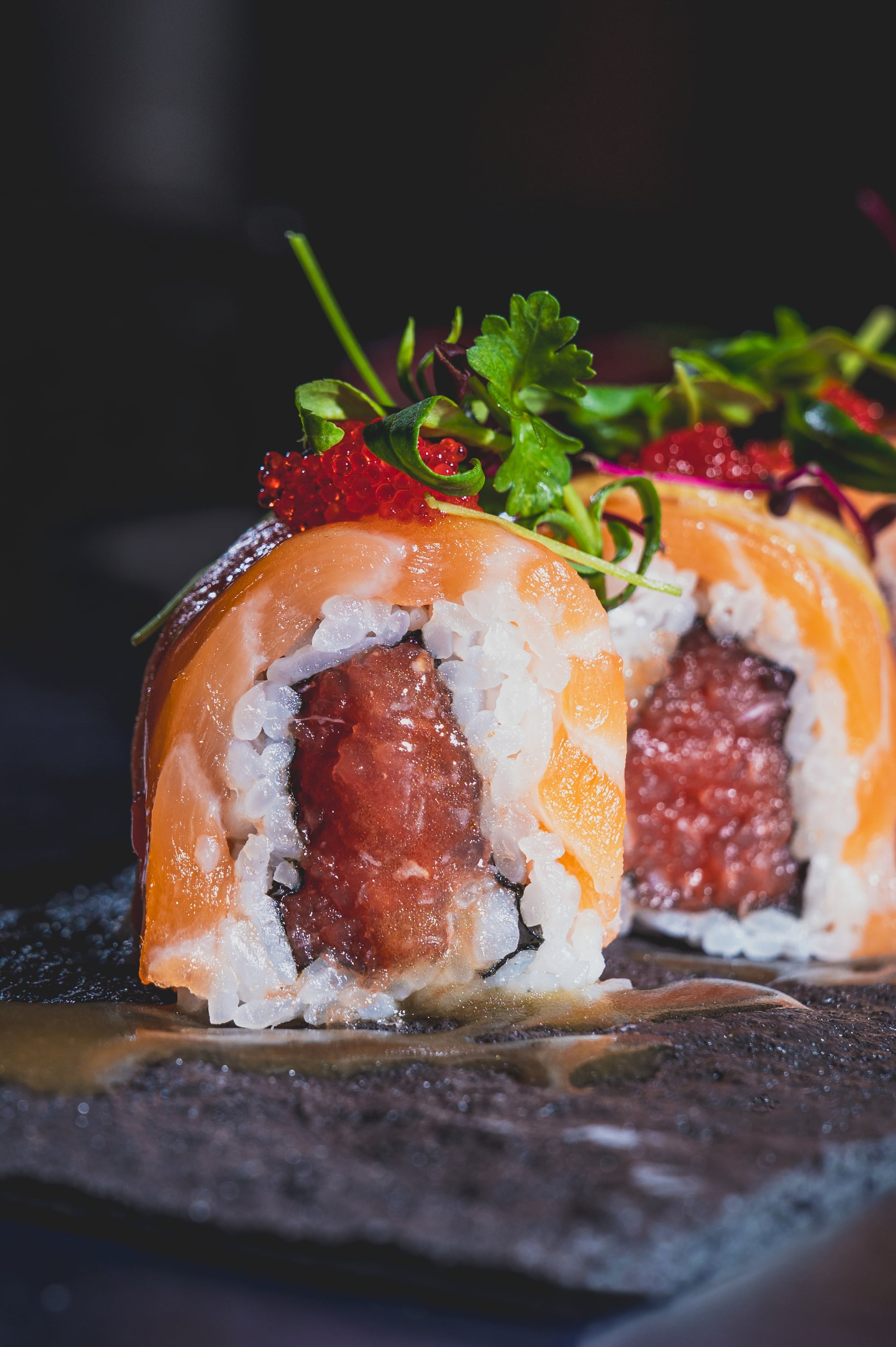 Salmon-wrapped sushi roll with spicy tuna and tobiko